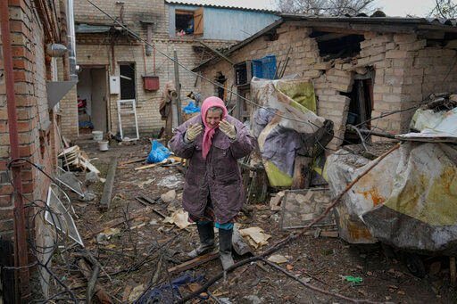 A woman is overwhelmed by emotion in the backyard of a house damaged by a Russian airstrike, according to locals, in Gorenka, outside the capital Kyiv, Ukraine, Wednesday, March 2, 2022. Russia renewed its assault on Ukraine