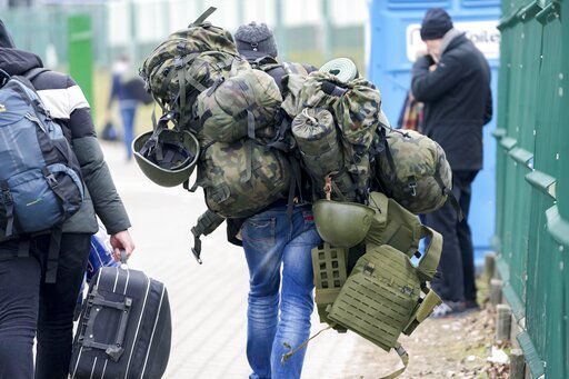 A man carries combat gear as he leaves Poland to fight in Ukraine, at the border crossing in Medyka, Poland, Wednesday, March 2, 2022. (AP Photo/Markus Schreiber)    PHOTO CREDIT: Markus Schreiber