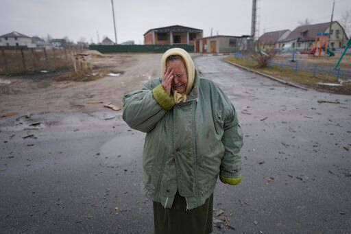 A woman cries outside houses damaged by a Russian airstrike, according to locals, in Gorenka, outside the capital Kyiv, Ukraine, Wednesday, March 2, 2022. Russia renewed its assault on Ukraine