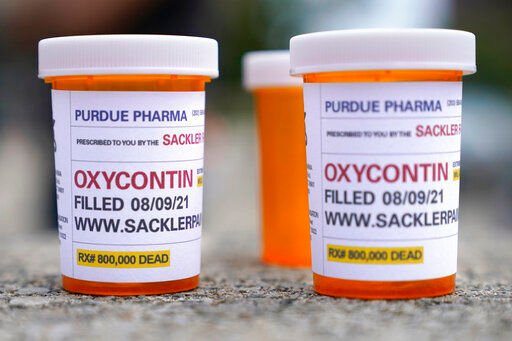 Fake pill bottles with messages about OxyContin maker Purdue Pharma are displayed during a protest outside the courthouse where the bankruptcy of the company took place in White Plains, N.Y., on Aug. 9, 2021.    PHOTO CREDIT: Seth Wenig