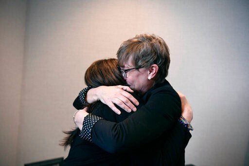 Liz Fitzgerald of Southington and Paige Niver of Manchester embrace at the end of a news conference at Connecticut Attorney General William Tong