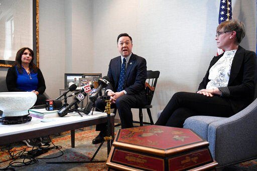 Liz Fitzgerald of Southington, left, and Paige Niver of Manchester, right, listen as Connecticut Attorney General William Tong, center, speaks at a news conference, Thursday, March 3, 2022, in Hartford, Conn. Fitzgerald lost two sons to opioids and Niver