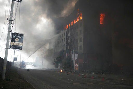 Firefighters hose down a burning building after bombing in Kyiv, Ukraine, Thursday, March 3, 2022. Russian forces have seized a strategic Ukrainian seaport and besieged another. Those moves are part of efforts to cut the country off from its coastline even as Moscow said Thursday it was ready for talks to end the fighting. (AP Photo/Efrem Lukatsky)    PHOTO CREDIT: Efrem Lukatsky