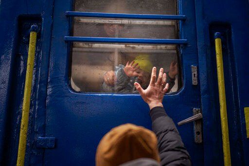 Stanislav, 40, says goodbye to his son David, 2, and his wife Anna, 35, on a train to Lviv at the Kyiv station, Ukraine, Thursday. Stanislav is staying to fight while his family is leaving the country to seek refuge in a neighboring country.    PHOTO CREDIT: Emilio Morenatti