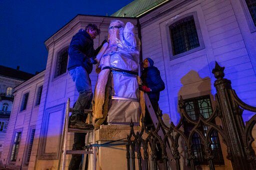 Ukrainians cover the sculptures of the Latin Cathedral in Lviv, western Ukraine, Thursday, March 3, 2022. Russia
