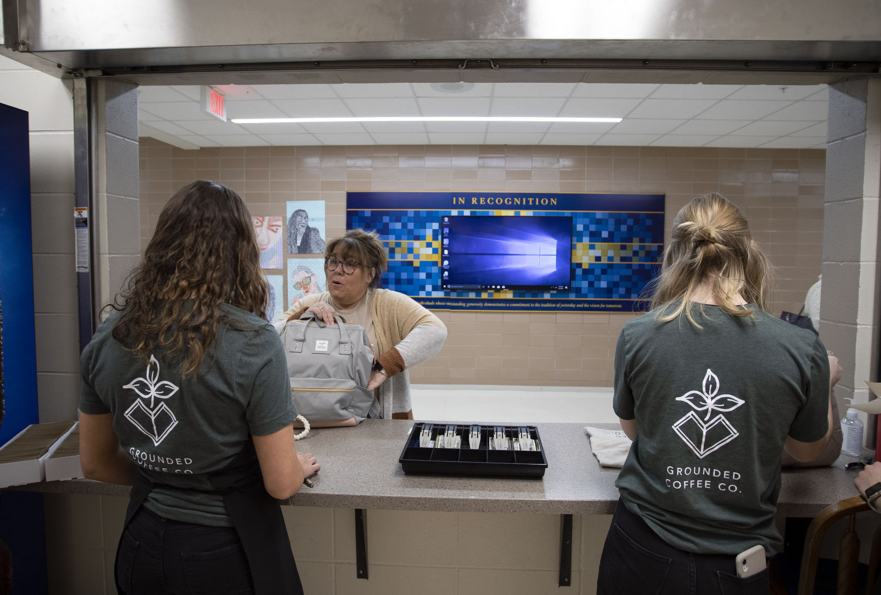 Izzy Ungs (left), 17, and Jamie Vondra, 18, take an order from teacher Jill Hohmann before class at Wahlert Catholic High School in Dubuque on Wednesday.    PHOTO CREDIT: Stephen Gassman