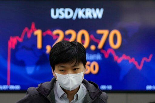 A currency trader walks near the screen showing the foreign exchange rate between U.S. dollar and South Korean won at a foreign exchange dealing room in Seoul, South Korea. The price of oil jumped more than $10 a barrel and shares were sharply lower today as the conflict in Ukraine deepened amid mounting calls for harsher sanctions against Russia.    PHOTO CREDIT: Lee Jin-man