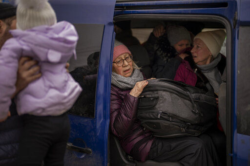 Ukrainian women sit inside a van as artillery echoes nearby, as people flee Irpin on the outskirts of Kyiv, Ukraine, Monday, March 7, 2022. Russia announced yet another cease-fire and a handful of humanitarian corridors to allow civilians to flee Ukraine. Previous such measures have fallen apart and Moscow
