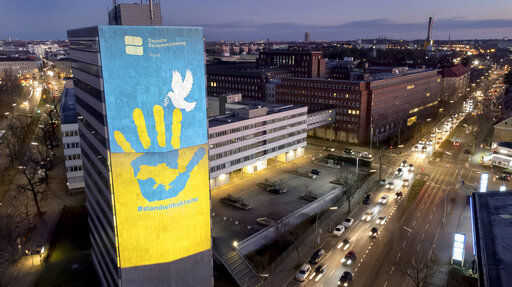 Cars drive past a pro-Ukraine projection on the fifteen floor high building of the 