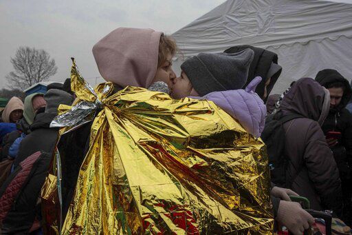 A woman kisses a child after fleeing from the Ukraine and arriving at the border crossing in Medyka, Poland, Monday, March 7, 2022. Russia announced yet another cease-fire and a handful of humanitarian corridors to allow civilians to flee Ukraine. Previous such measures have fallen apart and Moscow’s armed forces continued to pummel some Ukrainian cities with rockets Monday. (AP Photo/Visar Kryeziu)    PHOTO CREDIT: Visar Kryeziu