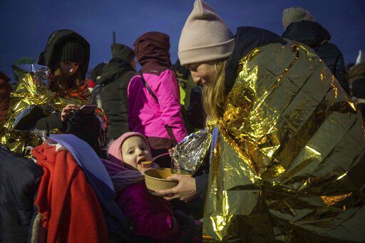 A woman feeds her daughter after fleeing Ukraine and arriving at the border crossing in Medyka, Poland, Monday, March 7, 2022. Russia announced yet another limited cease-fire and the establishment of safe corridors to allow civilians to flee some besieged Ukrainian cities Monday. But the evacuation routes led mostly to Russia and its ally Belarus, drawing withering criticism from Ukraine and others. (AP Photo/Visar Kryeziu)    PHOTO CREDIT: Visar Kryeziu