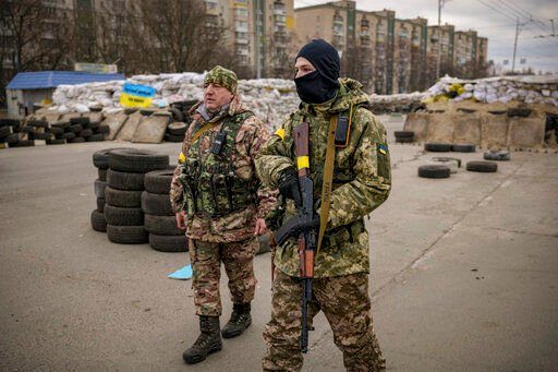 A Ukrainian serviceman has "Mommy" written on his weapon strap as he stands guard at a checkpoint on a main road in Kyiv, Ukraine, Monday, March 7, 2022. (AP Photo/Vadim Ghirda)    PHOTO CREDIT: Vadim Ghirda