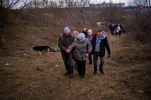 People flee Irpin on the outskirts of Kyiv, Ukraine, Monday, March 7, 2022, as the artillery echoes nearby. Russia announced yet another cease-fire and a handful of humanitarian corridors to allow civilians to flee Ukraine. Previous such measures have fallen apart and Moscow