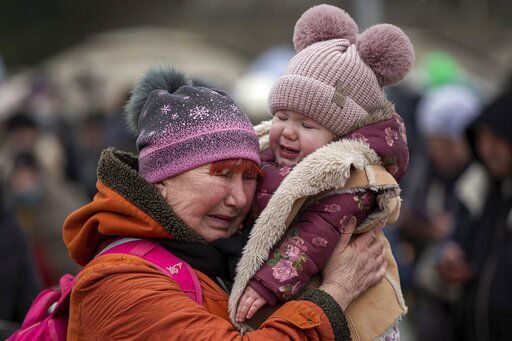 A woman holding a child cries after fleeing from the Ukraine and arriving at the border crossing in Medyka, Poland, Monday, March 7, 2022. Russia announced yet another cease-fire and a handful of humanitarian corridors to allow civilians to flee Ukraine. Previous such measures have fallen apart and Moscow’s armed forces continued to pummel some Ukrainian cities with rockets Monday. (AP Photo/Visar Kryeziu)    PHOTO CREDIT: Visar Kryeziu