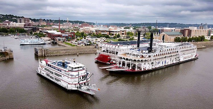 The 750-passenger Celebration Belle, from Moline, Ill., exits the Port of Dubuque on Aug. 14. Other excursion boats shown are the Riverboat Twilight (top left), of LeClaire, Iowa; the 166-passenger American Duchess; and the American Queen, dubbed “the largest steamboat ever built” by its Indiana owners.    PHOTO CREDIT: Dave Kettering