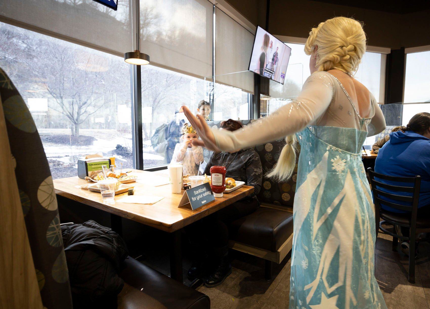 Traci Yeo, as Elsa, and owner of Royal T Princesses and Superheroes, sings to customers at Wahlburgers in Hy-Vee on South Locust Street in Dubuque on Friday.    PHOTO CREDIT: Stephen Gassman