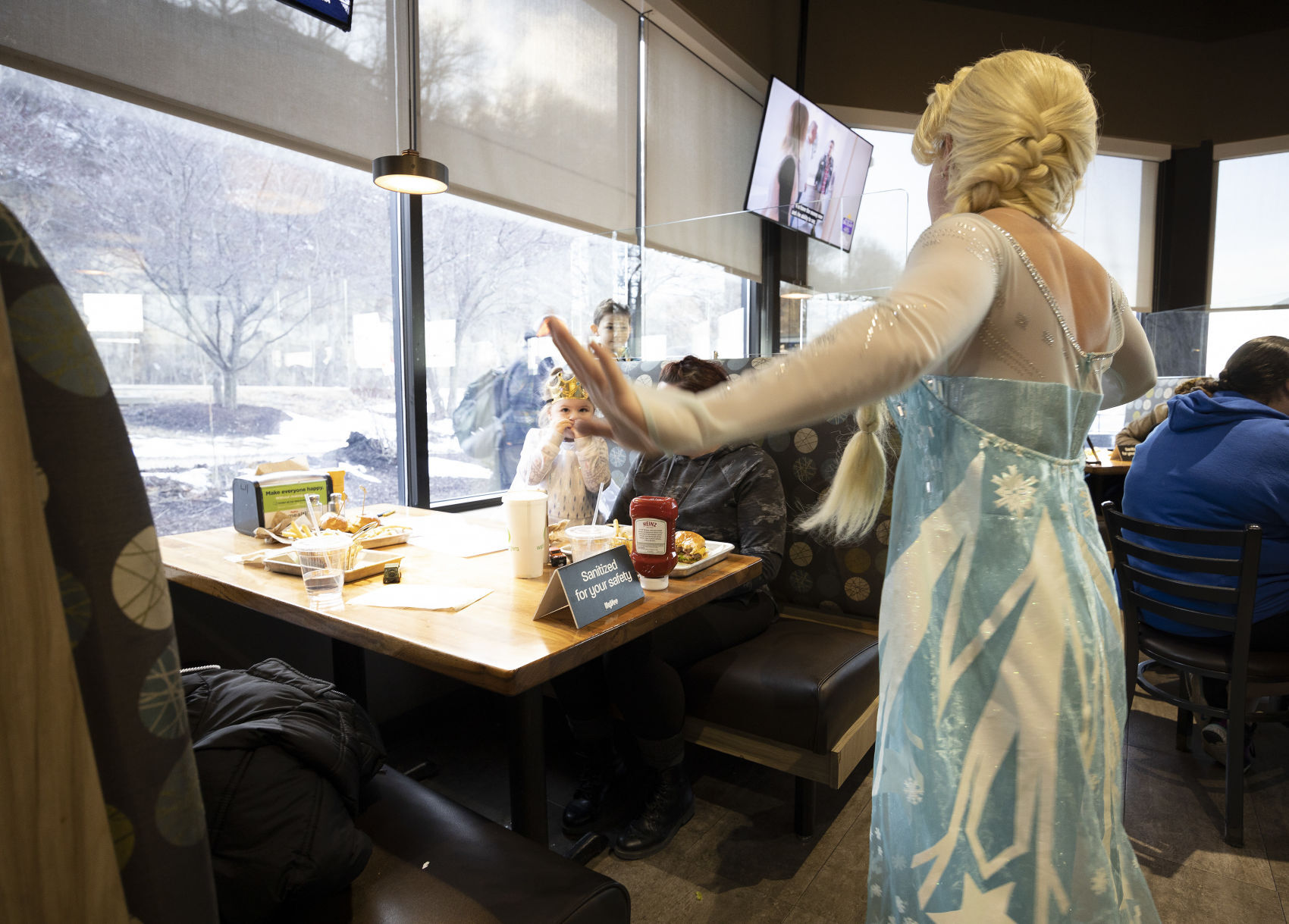 Traci Yeo, as Elsa, and owner of Royal T Princesses and Superheroes, sings to customers at Wahlburgers in Hy-Vee on South Locust Street in Dubuque on Friday, March 11, 2022.    PHOTO CREDIT: Stephen Gassman