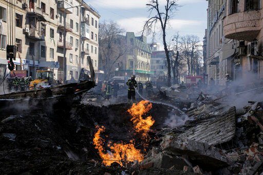 Firefighters extinguish flames outside an apartment house after a Russian rocket attack in Kharkiv, Ukraine