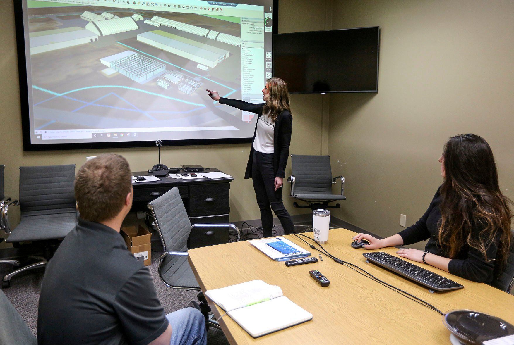 FarmTek General Manager Martina Bockenstedt (center) speaks with team members John Schemmel (left) and Danielle Will on Monday in Dyersville, Iowa. The company is planning a major expansion.    PHOTO CREDIT: Dave Kettering
