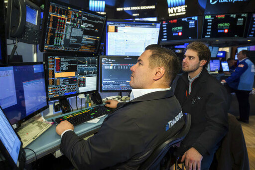 In this photo provided by the New York Stock Exchange, trader Tim Sela, left, works on the floor, Tuesday, March 15, 2022. Stocks are rallying on Wall Street Tuesday as oil prices slid sharply for a second day and inflation worries ebbed. (Courtney Crow/New York Stock Exchange via AP)    PHOTO CREDIT: Courtney Crow