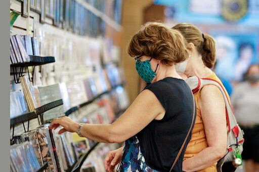 FILE - Judy Gallagher, left, wears a mask as she looks through music at the Ernest Tubb Record Shop Monday, June 29, 2020, in Nashville, Tenn. The Nashville record store that was opened by Opry legend Ernest Tubb in 1947 will close as the building is being put up for sale. Owners announced on Friday that the shop on Broadway will close in the spring after being in its current location since 1951, citing circumstances “beyond our control.” (AP Photo/Mark Humphrey, File)    PHOTO CREDIT: Mark Humphrey