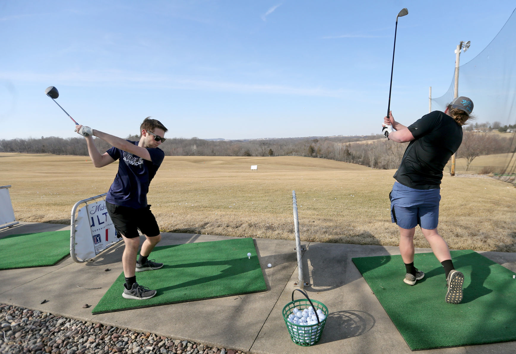 Carson Schiller (left) and Dalton Creighton, both students at University of Dubuque, hit balls at Derby Grange Golf & Recreation in Dubuque on Wednesday, March 16, 2022.    PHOTO CREDIT: JESSICA REILLY