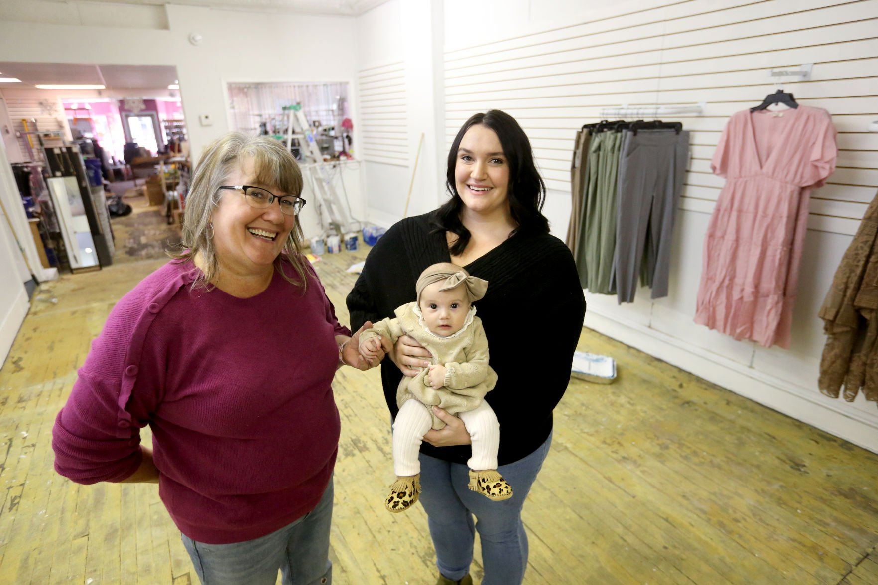 Terri Meadows (left) and Anna Meadows, who is holding her daughter, Amina Zulic, 4 months, stand at Momerella in Dubuque on Monday. The new store will be located at the former HJ