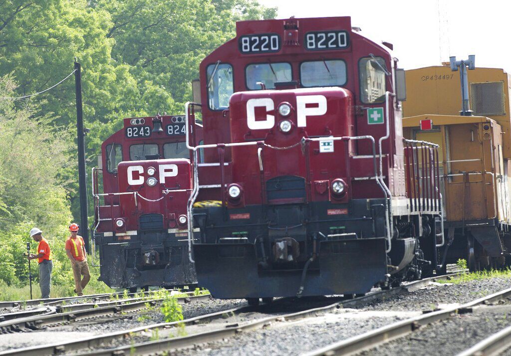 Surveyors work next to Canadian Pacific Rail trains. Approximately 3,000 Canadian Pacific Railway conductors, engineers, train and yard workers represented by the Teamsters Canada Rail Conference will return to work today after an agreement was reached between the railroad operator and union.    PHOTO CREDIT: Nathan Denette/The Canadian Press via AP