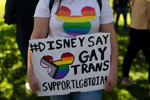 Disney employee Tiffany Cooper holds a sign to protest the company