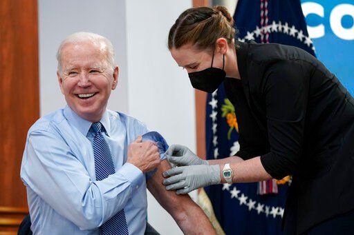 President Joe Biden smiles after receiving his second COVID-19 booster shot in the South Court Auditorium on the White House campus, Wednesday, March 30, 2022, in Washington. (AP Photo/Patrick Semansky)    PHOTO CREDIT: Patrick Semansky