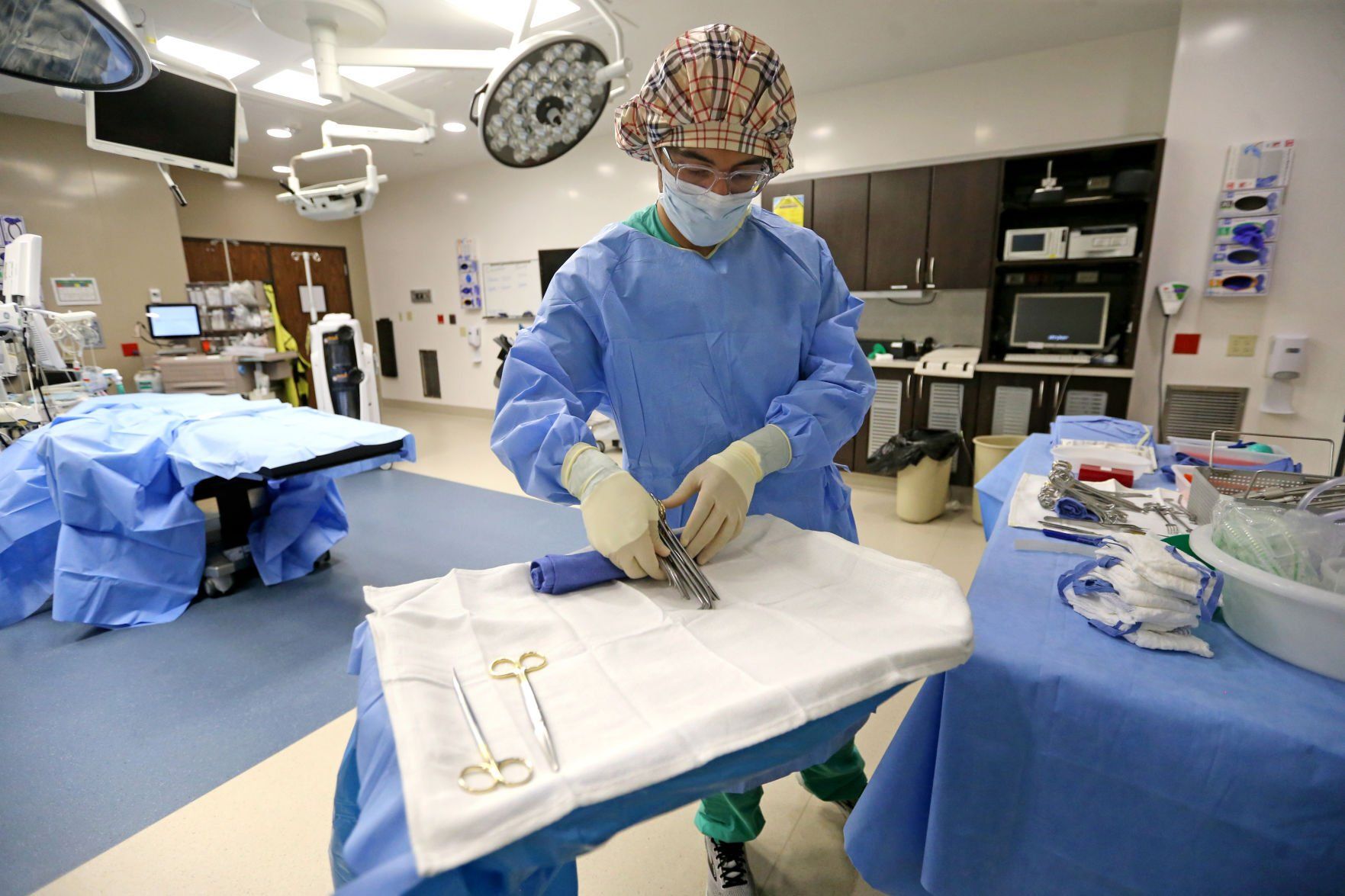 Jerry-Jordan Kane, a surgical technician at MercyOne Dubuque Medical Center, demonstrates how to prepare a mayo stand in an operating room at the hospital in Dubuque on Friday.    PHOTO CREDIT: JESSICA REILLY