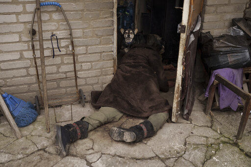 A dog stands next to the body of an elderly woman killed at the entrance of her house in Bucha, outskirts of Kyiv, Ukraine, Tuesday, April 5, 2022. (AP Photo/Felipe Dana)    PHOTO CREDIT: Felipe Dana