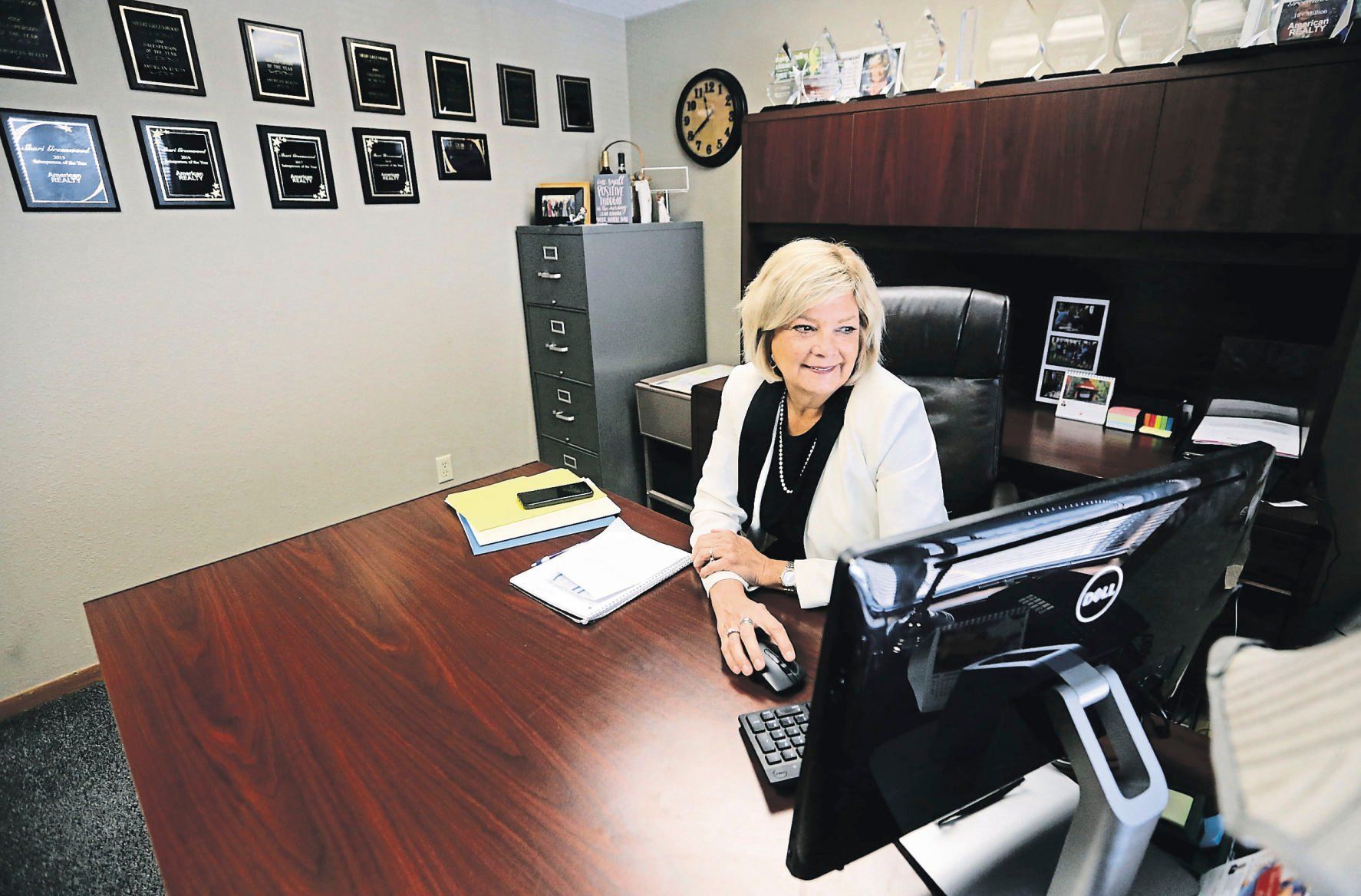 Shari Greenwood looks through files at American Realty in Dubuque.    PHOTO CREDIT: JESSICA REILLY