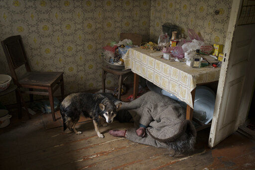 A dog stands next to the body of an elderly woman killed inside a house in Bucha, outskirts of Kyiv, Ukraine, Tuesday, April 5, 2022. (AP Photo/Felipe Dana)    PHOTO CREDIT: Felipe Dana