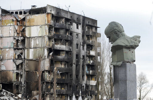A monument to Taras Shevchenko, a Ukrainian poet and a national symbol, in seen with traces of bullets against the background of an apartment house ruined in the Russian shelling in the central square in Borodyanka, Ukraine, Wednesday, Apr. 6, 2022. (AP Photo/Efrem Lukatsky)    PHOTO CREDIT: Efrem Lukatsky