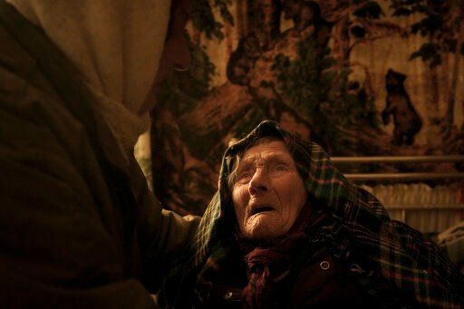 Motria Oleksiienko, 99 years-old, traumatized by the Russian occupation, is comforted by daughter-in-law Tetiana Oleksiienko in a room without heating in the village of Andriivka, Ukraine, heavily affected by fighting between Russian and Ukrainian forces, Wednesday, April 6, 2022. Several buildingsa in the village were reduced to mounds of bricks and corrugated metal and residents struggle without heat, electricity or cooking gas. (AP Photo/Vadim Ghirda)    PHOTO CREDIT: Vadim Ghirda