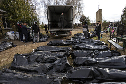 Cemetery workers load the corpses of civilians killed in Bucha into a truck, to be transported to the morgue, on the outskirts of Kyiv, Ukraine, Wednesday, April 6, 2022. (AP Photo/Rodrigo Abd)    PHOTO CREDIT: Rodrigo Abd