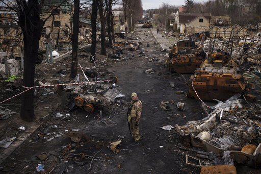 A Ukrainian serviceman stands amid destroyed Russian tanks in Bucha, on the outskirts of Kyiv, Ukraine, Wednesday, April 6, 2022. (AP Photo/Felipe Dana)    PHOTO CREDIT: Felipe Dana