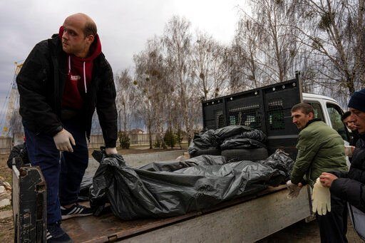 Cemetery workers receive three corpses of civilians killed in Bucha, before the corpses are transported to the morgue, on the outskirts of Kyiv, Ukraine, Wednesday, April 6, 2022. (AP Photo/Rodrigo Abd)    PHOTO CREDIT: Rodrigo Abd
