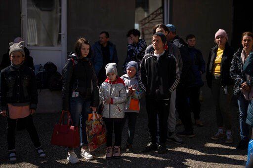 People wait to take the bus at the city of Bashtanka, Ukraine, after fleeing from nearby villages which have been attacked by the Russian forces in the Mykolaiv district, on Thursday, April 7, 2022. (AP Photo/Petros Giannakouris)    PHOTO CREDIT: Petros Giannakouris