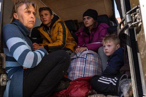 From left to right, Oksana Gavrielutca 41, sits at the back of a bus with her children Oleg 18, Diana 17 and Vlad 5 after they flee from Snigiriovka village, in Mikolaiv district, Ukraine, on Thursday, April 7, 2022. (AP Photo/Petros Giannakouris)    PHOTO CREDIT: Petros Giannakouris
