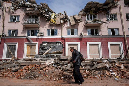 A man walks past an apartments building damaged by shelling in Chernihiv, Ukraine, Thursday, April 7, 2022. Ukraine is telling residents of its industrial heartland to leave while they still can after Russian forces withdrew from the shattered outskirts of Kyiv to regroup for an offensive in the country