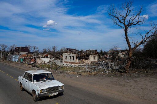 A car moves in a street past damaged houses in Chernihiv, Ukraine, Thursday, April 7, 2022. Ukraine is telling residents of its industrial heartland to leave while they still can after Russian forces withdrew from the shattered outskirts of Kyiv to regroup for an offensive in the country