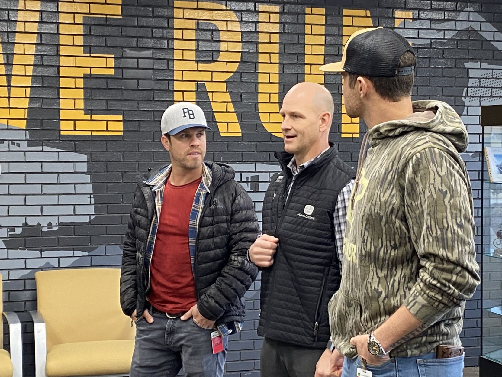 Country music star Dustin Lynch (left) and country singer Sean Stemaly (right) listen to John Deere Dubuque Works General Manager Mark Dickson during a tour of the facility Thursday afternoon.    PHOTO CREDIT: Contributed