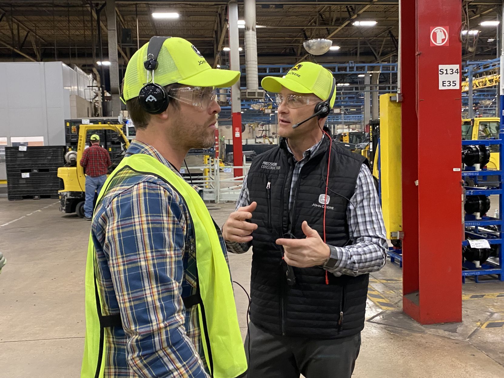 Country music star Dustin Lynch listens to John Deere Dubuque Works General Manager Mark Dickson during a tour of the facility Thursday afternoon.     PHOTO CREDIT: Contributed
