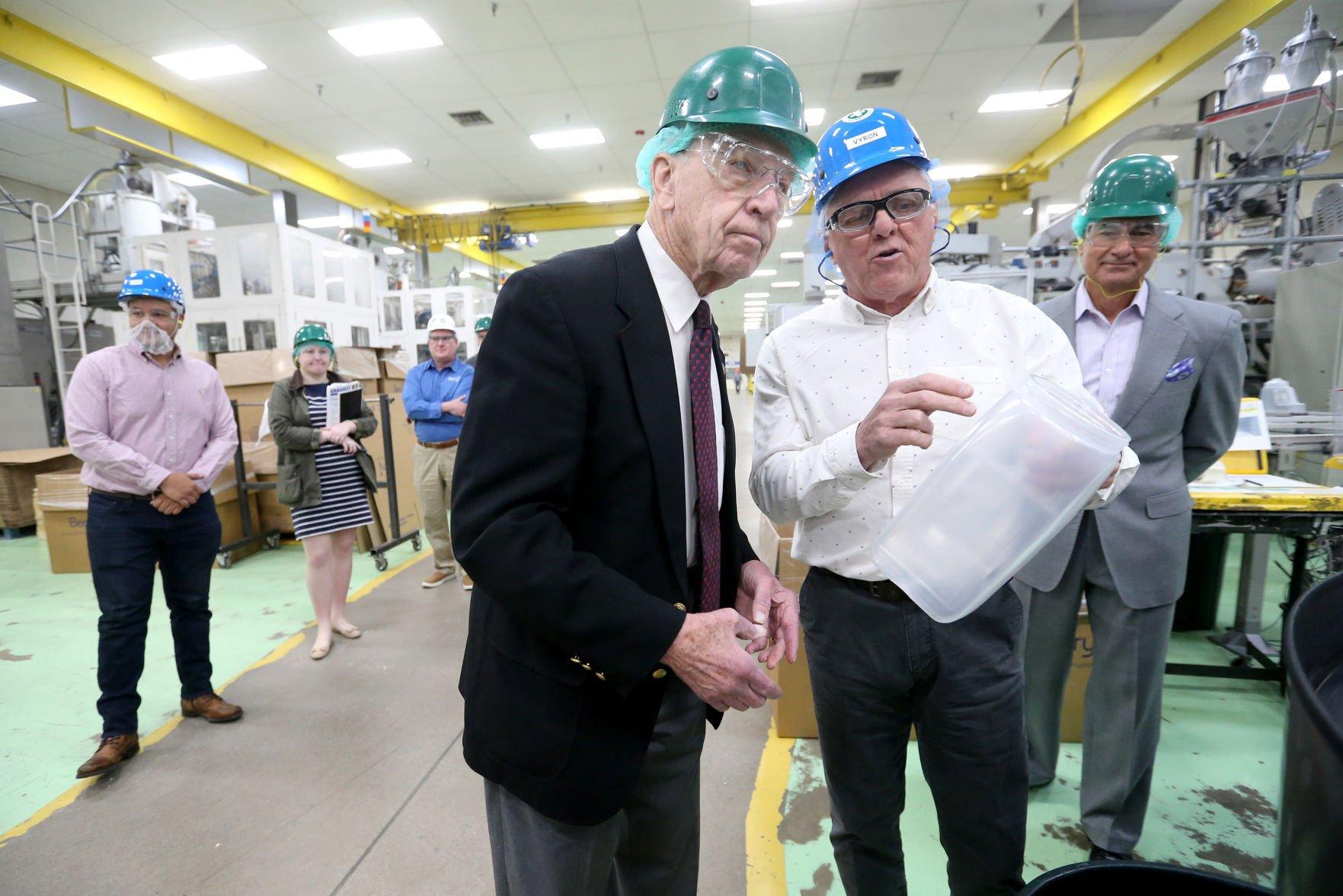 U.S. Sen. Chuck Grassley (left), R-Iowa, speaks with Vyron Nelson, plant manager at Berry Plastics, while Tom Salmon (far right), president and CEO at Berry Plastics, watches during a tour of the company’s facility in Peosta, Iowa, on Tuesday.    PHOTO CREDIT: JESSICA REILLY