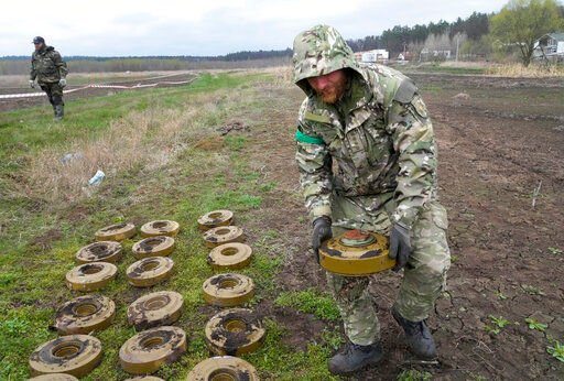 An interior ministry sapper collects mines on a mine field after recent battles in Irpin close to Kyiv, Ukraine, Tuesday, April 19, 2022. (AP Photo/Efrem Lukatsky)    PHOTO CREDIT: Efrem Lukatsky