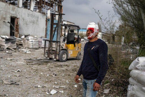 An injured man looks on following a Russian bombing of a factory in Kramatorsk, in eastern Ukraine, on Tuesday, April 19, 2022. Russian forces attacked along a broad front in eastern Ukraine on Tuesday as part of a full-scale ground offensive to take control of the country