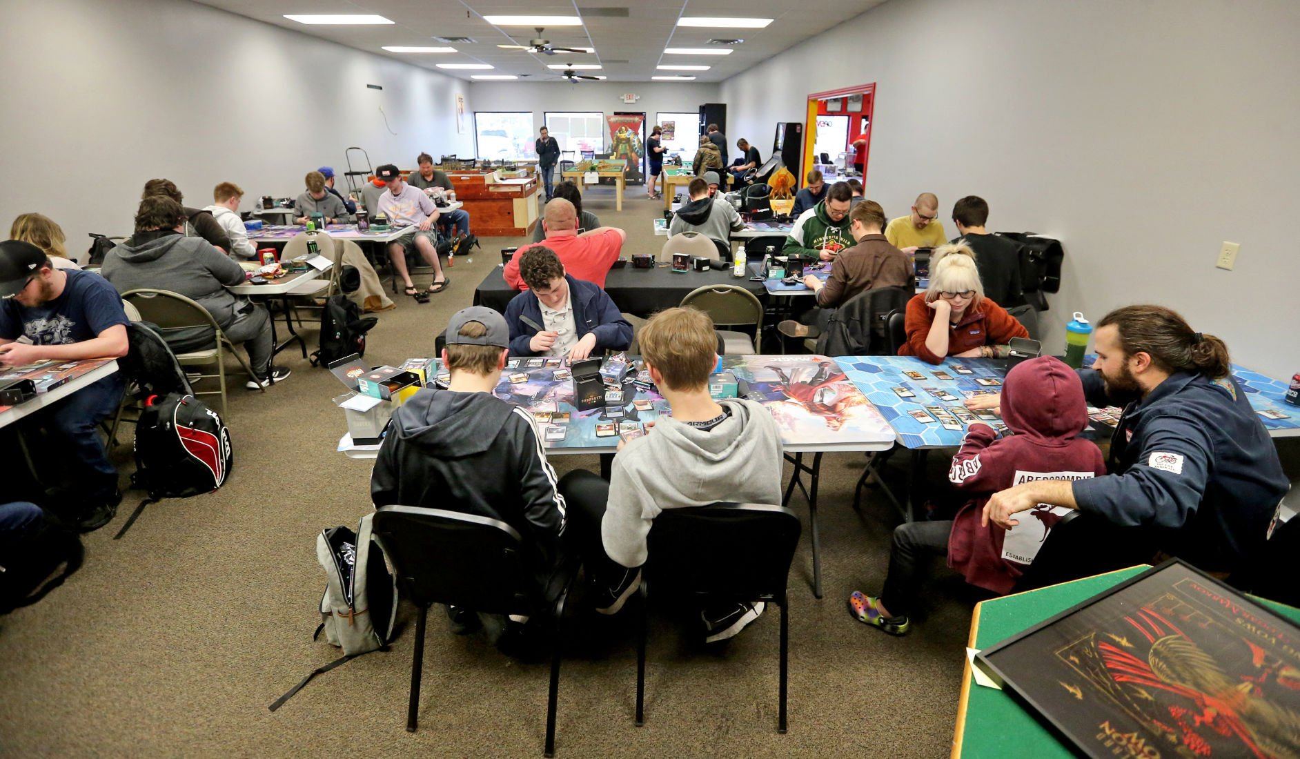 People sort cards at Comic World & Games in Dubuque on Friday, April 22, 2022. The business recently added 2,000 more square feet of space for in-person gaming.    PHOTO CREDIT: JESSICA REILLY