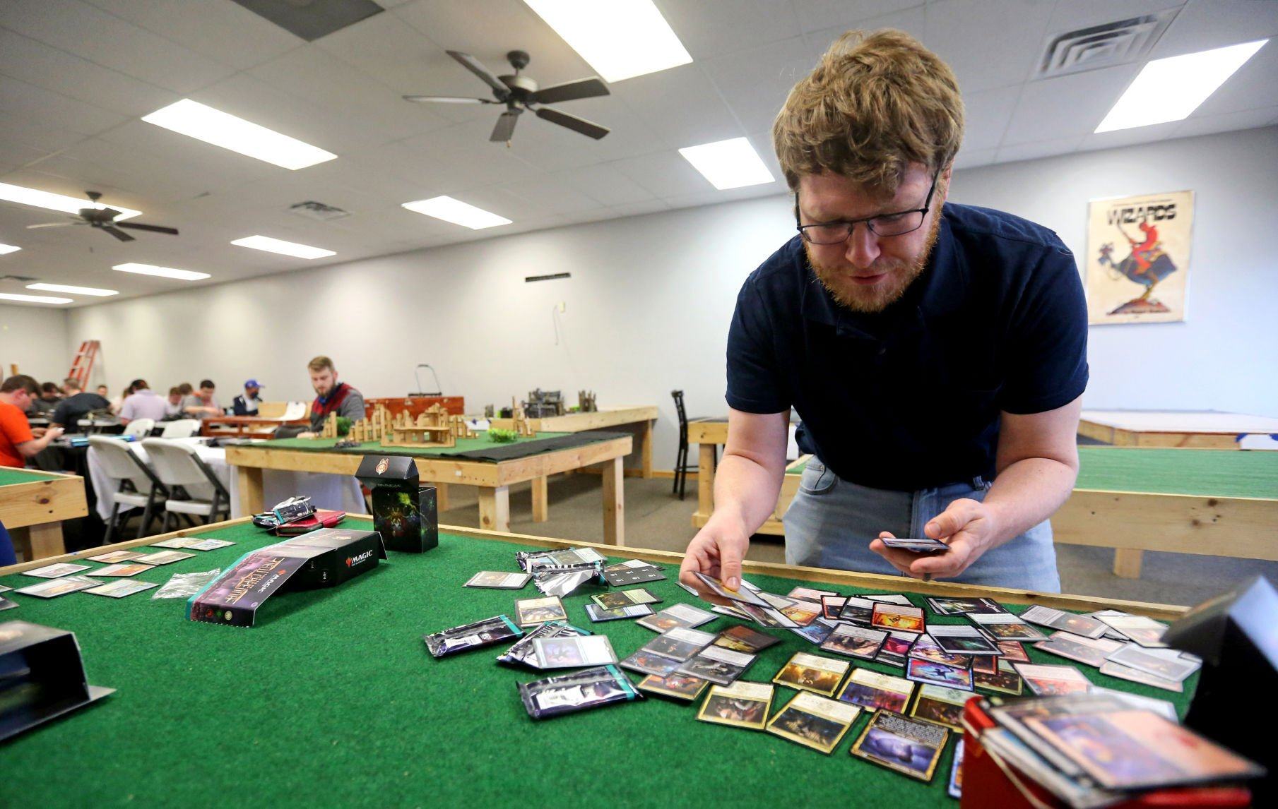 Garrett Bizzell, of Dubuque, sort cards at Comic World & Games in Dubuque on Friday, April 22, 2022. The business recently added 2,000 more square feet of space for in-person gaming.    PHOTO CREDIT: JESSICA REILLY